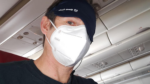 picture of a man with a sleep mask on a plane